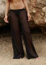 Pantalón de playa confeccionado en gasa brillante semitransparente, con corte relajado y cintura elástica.