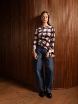 Blusa de terciopelo con estampado a cuadros, corte asimétrico y mangas largas acampanadas.
