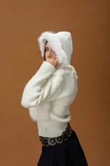 Campera corta de diseño combinado en color marrón. Presenta cuerpo de piel sintética con capucha, mangas tejidas en punto acanalado y cierre frontal con vista de cuero sintético. Incluye detalles de pompones laterales en el ruedo.