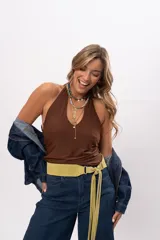 Faja de cuero gamuza color pistacho, con diseño curvado, herrajes plateados y cierre de nudo con flecos largos.