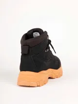 Bota de trekking color rosado con cordones al tono, cuello acolchado, ganchos metálicos para los cordones y suela dentada con plataforma gris y caramelo.