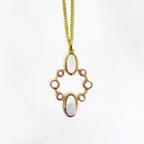 Collar con cadena de eslabones dorados y dije colgante de diseño geométrico en bronce. El dije presenta dos óvalos centrales de nácar y está rodeado por ocho cuentas pequeñas de perla o piedra blanca, engastadas en aros de bronce.