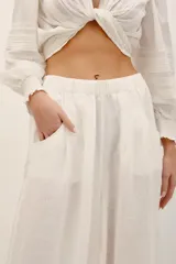 Pantalón babucha negro de lino, de corte holgado estilo barrel con pinzas en la cintura y bolsillos laterales.