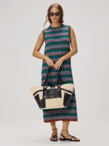 Vestido midi sin mangas de corte holgado, con diseño de rayas horizontales en tonos verde azulado, marrón y rosado. Presenta cuello redondo y aberturas laterales en el dobladillo.