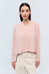 Sweater de tejido de punto color beige, con escote en V y calce holgado.