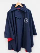Poncho azul marino con interior rojo, confeccionado en neopreno por fuera y polar por dentro, con cuello alto, solapa abotonada y bordado de caballo en el pecho.