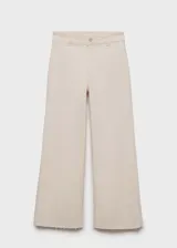Jeans de tiro alto, corte culotte y pernera recta con bajo deshilachado. Confeccionados en tejido elástico de algodón estilo denim, cuentan con cierre de cremallera y botón, trabillas para cinturón y bolsillos traseros.