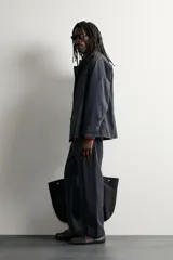 Sobrecamisa de algodón de corte relajado, color negro con efecto gastado, cuello con solapas de muesca, mangas largas raglán y cierre frontal con botones. Cuenta con bolsillos frontales de plastrón en el pecho y en la parte inferior.