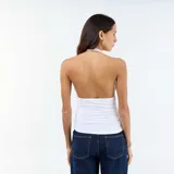 Top blanco de diseño ajustado con cuello halter y escote en V pronunciado, con fruncidos laterales en el cuerpo.
