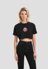 Remera cropped de algodón, color gris claro, con cuello redondo y manga corta doblada. Presenta un estampado frontal de un plátano amarillo.