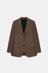 Blazer de Zara confeccionado en hilatura con lana, con diseño de espiga en tonos marrones. Presenta cuello solapa, manga larga con botones, bolsillo de vivo en el pecho y bolsillos delanteros con solapa. Cierre frontal con botones y forro interior negro.