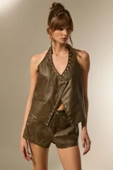 Top halter de eco-cuero color marrón verdoso, con escote en V profundo y bordes decorados con tachas plateadas.