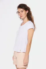 Remera color beige con cuello redondo, mangas cortas, bolsillo pequeño en el pecho y media botonadura frontal.