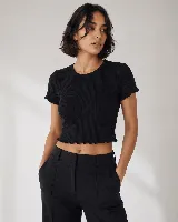 Remera de morley de algodón color negro, con cuello redondo, manga corta y terminaciones con borde fruncido.