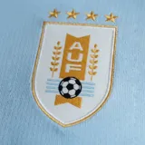 Camiseta de fútbol Nike de la selección uruguaya, modelo local 2026. Diseño en color celeste con cuello tipo polo blanco y cierre de botones. Incluye el escudo de la AUF con cuatro estrellas y el logo de Nike en el frente. Confeccionada con tecnología Dri-FIT para mayor transpirabilidad.