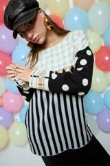 Sweater de punto con diseño geométrico y a rayas, de corte holgado y manga larga. Presenta un patrón combinado de lunares en las mangas, rombos en la parte superior y rayas verticales en el cuerpo.