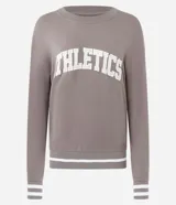 Buzo deportivo de corte oversized color gris topo, con cuello redondo, mangas largas y puños con detalle de rayas blancas. Presenta estampado frontal con la palabra Athletics y ruedo con franja blanca contrastante.