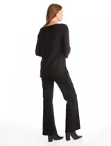 Buzo de tejido fino en color negro, con cuello redondo decorado con apliques de strass. Presenta mangas tres cuartos con puños acanalados y aberturas laterales en el ruedo.