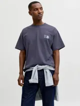 Remera gris oscuro de manga corta y cuello redondo, con corte holgado y pequeño estampado en el pecho.