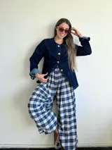 Pantalón de corte amplio y holgado, confeccionado en franela con estampado de tartán escocés en tonos azul, negro y beige. Presenta cintura elástica para un ajuste cómodo.