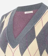 Chaleco de punto corto con diseño de rombos en tonos gris y beige. Presenta escote en V, sisas amplias y terminaciones acanaladas en el ruedo y el cuello.