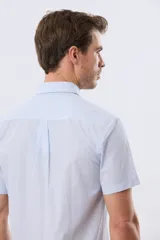 Camisa de manga corta a rayas celestes y blancas, con cuello abotonado, bolsillo frontal en el pecho con logo bordado y cierre frontal de botones.