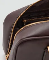 Bolso de mano de poliuretano color marrón oscuro, con diseño rectangular estructurado, cierre de solapa frontal y asa corta de hombro.