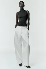 Camiseta sin mangas de corte ajustado con cuello subido, confeccionada en tejido liso de color marrón.