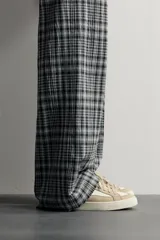 Zapatilla casual de tejido de algodón color beige con detalles en verde y un parche negro en el talón. Cuenta con suela de goma texturizada a contraste.