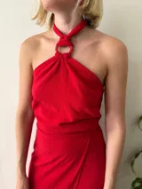 Conjunto de dos piezas color rojo. Incluye un top halter con argolla decorativa en el escote y lazo ajustable en el contorno. La falda es larga, recta y de diseño cruzado regulable.