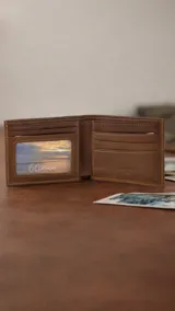 Billetera de cuero color marrón claro, con interior que incluye visor, tarjeteros y doble compartimento para billetes.