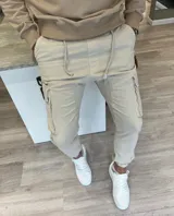 Pantalón jogger cargo beige con bolsillos laterales en las piernas y cordón ajustable en la cintura.
