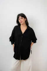 Camisa negra de manga larga con botones, de corte clásico.