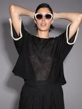 Sweater negro de tejido de punto calado, con mangas cortas amplias y detalle de lurex en los bordes color crudo.