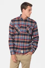 Sobrecamisa de viyela gruesa con diseño de cuadros en tonos azul y bordó. Cuenta con cuello clásico, cierre frontal con botones y dos bolsillos delanteros con solapa y botón.