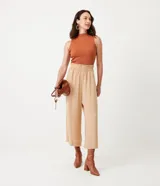 Pantalón pantacourt color beige, con cintura elástica y bolsillos laterales.