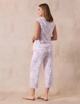Conjunto de pijama marca René Rofé, compuesto por remera de mangas cortas con escote en V abotonado y pantalón capri con cintura elastizada. Diseño estampado con flores azules sobre fondo blanco.