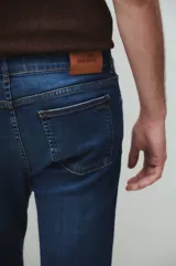 Jeans azul de tiro medio, corte recto y lavado stone wash con bigotes láser.