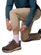 Pantalón Columbia de trekking convertible en bermuda, modelo Leslie Convert Pant Omni-Shade, color beige, con perneras desmontables mediante cremallera, bolsillos laterales y tecnología de protección solar.
