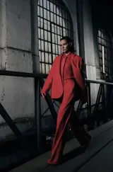 Conjunto de sastrería compuesto por un blazer de corte estructurado con solapas clásicas y un pantalón de vestir de tiro alto, corte recto y pernera ancha con pliegues frontales. Incluye una camisa a tono con corbata integrada.