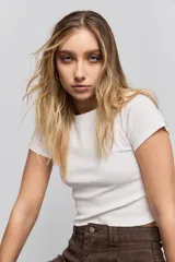 Remera de manga corta confeccionada en tejido de rib, con cuello redondo y ajuste al cuerpo.