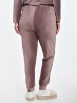 Pantalón de dormir tipo jogging confeccionado en plush acanalado de tacto suave. Presenta cintura elastizada con cordón ajustable, bolsillos laterales y puños elastizados en los tobillos.