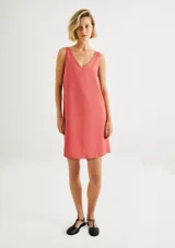 Vestido corto sin mangas de color rosado, con silueta recta y escote en V pronunciado.