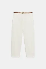 Pantalón chino color crudo, de tiro medio, con bolsillos frontales y falsos bolsillos de vivo en la espalda. Incluye cinturón trenzado marrón.