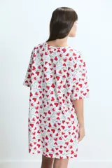 Camisón de algodón con estampado de corazones rojos y frases románticas sobre fondo blanco, de corte holgado y manga corta.