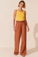 Pantalón de vestir color marrón, de corte palazzo, con cintura alta y cinturón fino de cuero marrón.