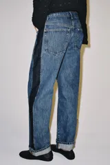 Jeans wide leg de tiro medio y corte recto de Zara, con efecto lavado y detalle de paneles de denim oscuro a contratono en los laterales. Cuenta con bolsillos clásicos y botamangas con vuelta.