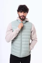 Chaleco acolchado de nylon en color verde menta, con cierre frontal completo y cuello alto. Diseño ligero y sin mangas, ideal para superposición de capas.