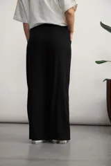 Pantalón de corte ancho y tiro alto, confeccionado en tejido de textura natural. Presenta cintura elástica con cordón ajustable, bolsillos laterales tipo parche y diseño de pierna recta y holgada.