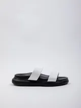 Sandalia baja de dos tiras anchas, color blanco, con plataforma negra de 2 cm de altura.